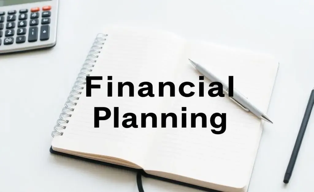 Clean, modern image of a desk with a notebook and a calculator for financial planning.