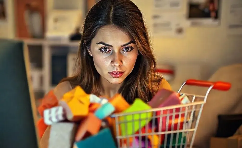 A woman staring at her overflowing online shopping cart