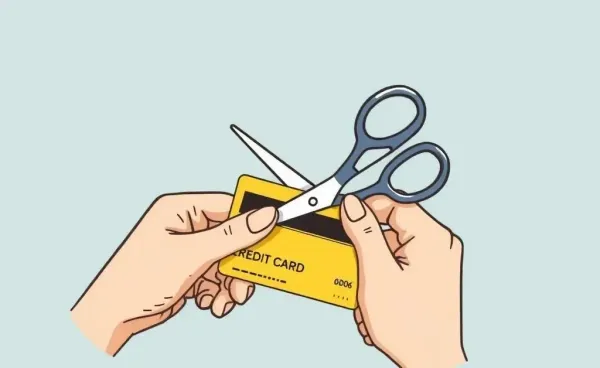 Person cutting up a credit card with scissors for security