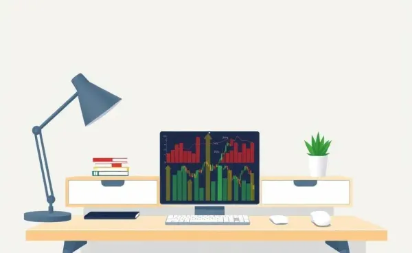 Office desk with a laptop displaying stock market graphs